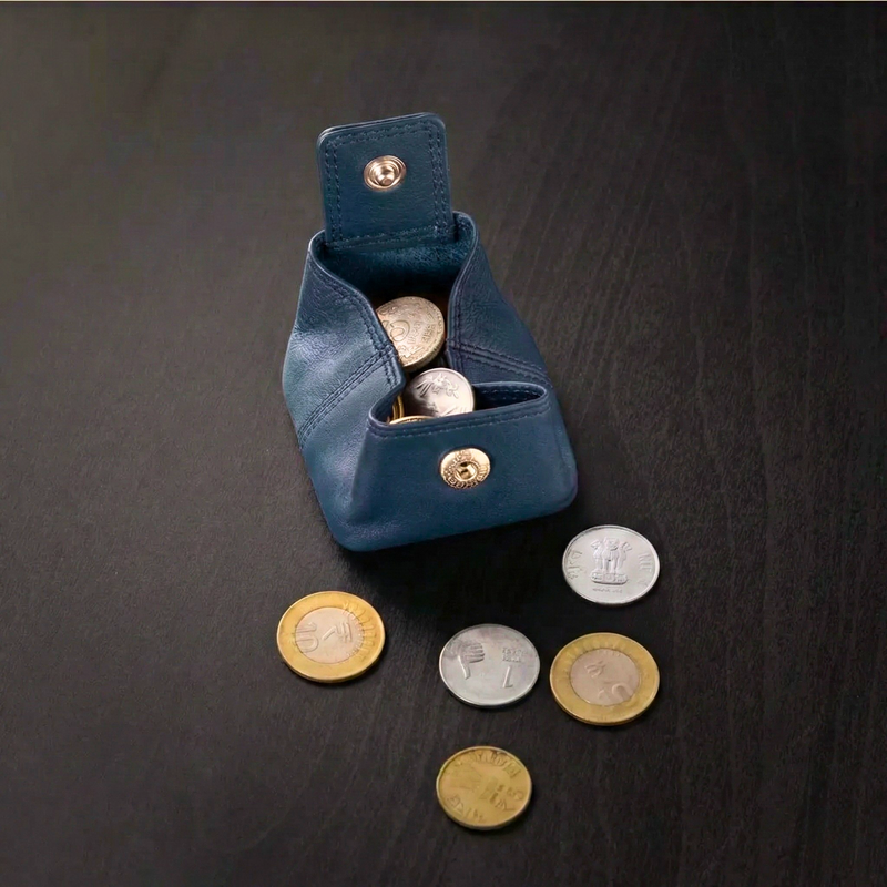 Blue leather coin pouch with coins on a dark surface

